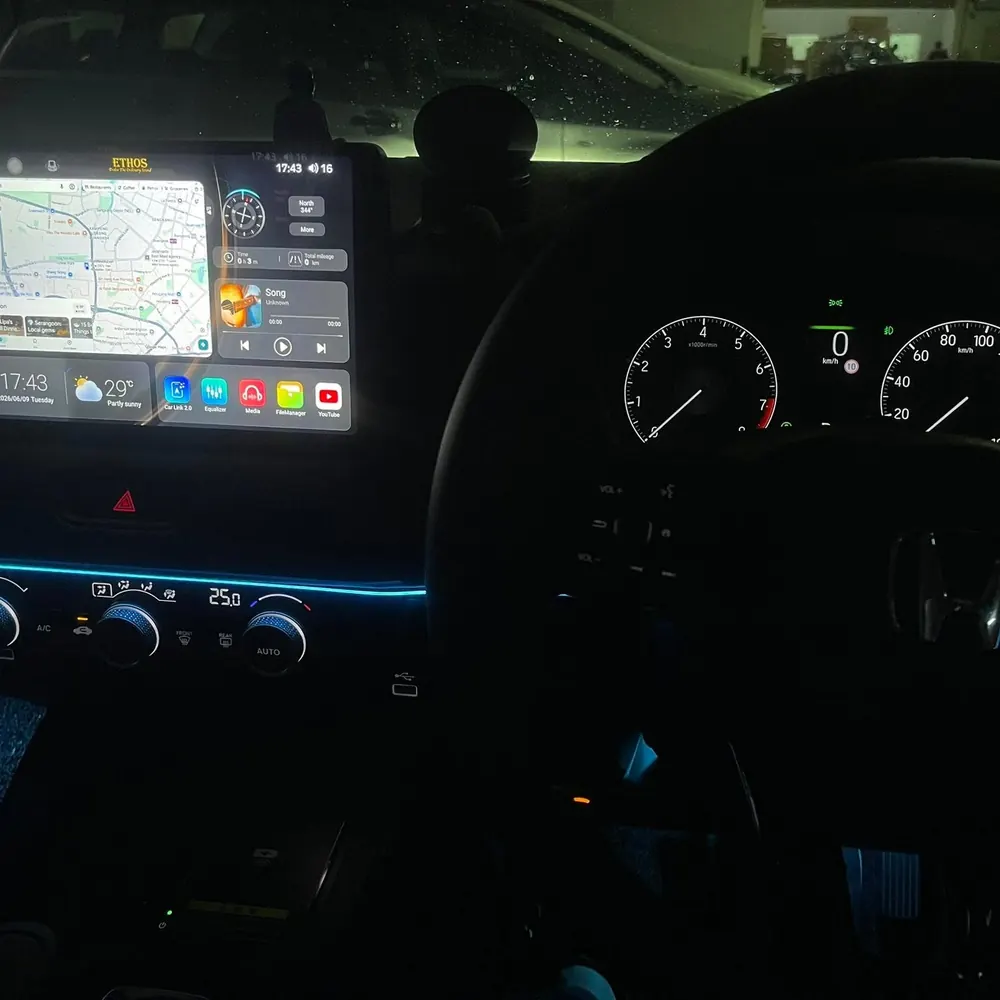 Android head unit glowing in a car dashboard at night with ambient lighting
